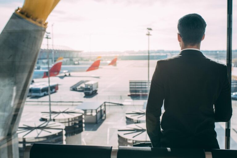 back-young-business-man-standing-with-suitcase-airport-waiting-flight-xa_657883-704